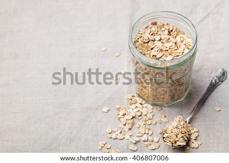 Healthy breakfast Organic oat flakes in a glass jar Grey textile background Copy space