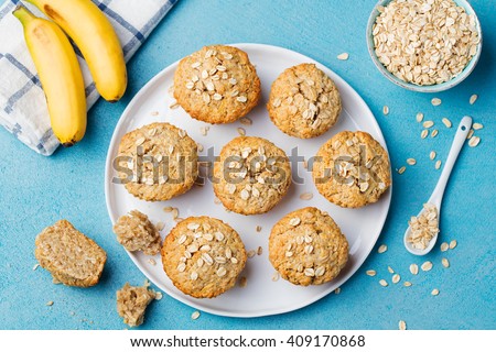 Healthy vegan oat muffins, apple and banana cakes with sour cream on a white plate Blue stone background Top view