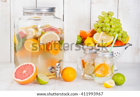 Detox fruit infused flavored water, lemonade, cocktail in a beverage dispenser with fresh fruits Cleanse body and burn fat