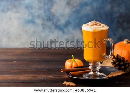 Pumpkin spice latte, smoothie, Boozy cocktail  with whipped cream on top on a wooden background. Copy space