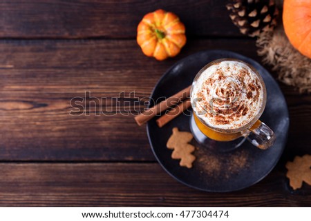 Pumpkin smoothie, spice latte. Boozy cocktail with whipped cream on top on a wooden background. Copy space Top view