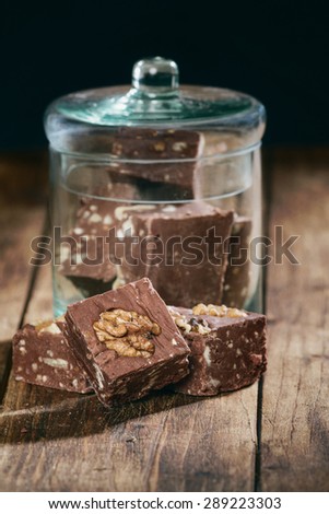 Closeup of homemade nuts chocolate in a glass jar on a wooden table/Homemade nuts chocolate in a glass jar/chocolate
