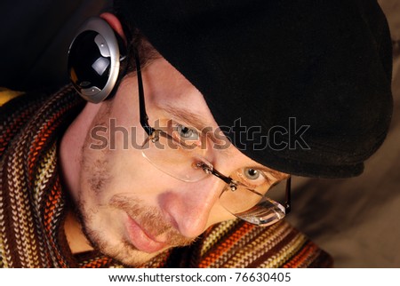 Young Man listening to music with headphones on dark background