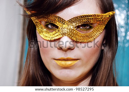 Close-up portrait of a beautiful brunette in a masquerade mask.