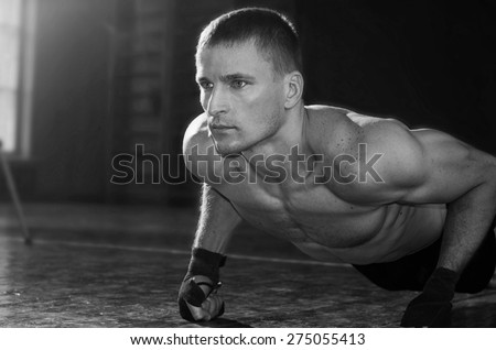 Young sporty man pushed off the floor. Black and white photo.