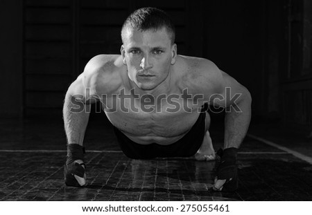 Young sporty man pushed off the floor. Black and white photo.