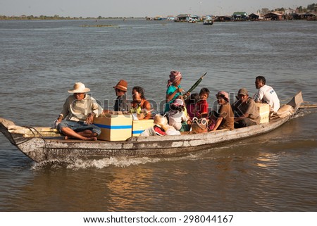 Boat with residents of the settlement on the water with a floating market - December 2, 2009, the boat is heavily overloaded with people, but they are not confused. Tonle Sap Lake in Cambodia.