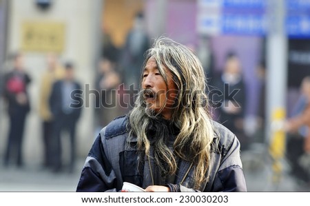 SHANGHAI - NOV 13: Unidentified old man beggar waits for alms on a street in China on november 13 2013 in  Shanghai