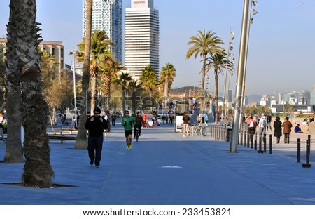 BARCELONA - MAR 08: many people walk and resting along side of famous Barceloneta sand beach on March 08.2014 in Spain