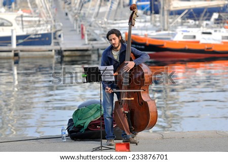 BARCELONA - MAR 12: Street Performer Plays violin at Mediterranean Sea on March 12.2014 in Spain, Barcelona.