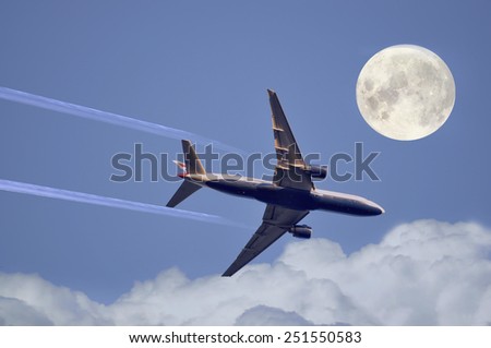 The big airplane flying across a full moon