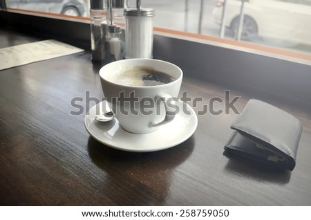White cup with black coffee during the sunrise