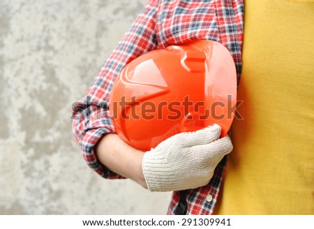 Hand of worker with red hard-hat