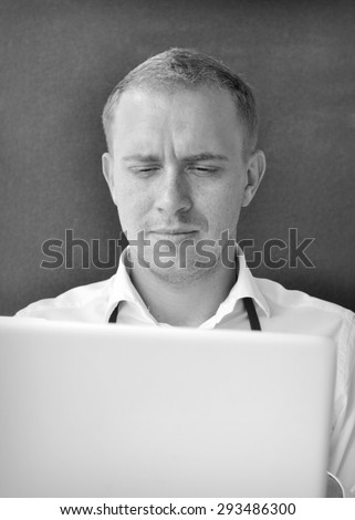 Young guy at the work with a laptop - black and white photo