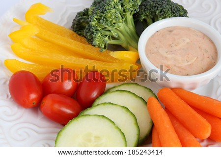 Raw vegetables Ã¢Â?Â? broccoli, pepper, tomato, cucumber, carrot Ã¢Â?Â? on white plate with dip