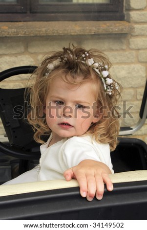 adorable bridesmaid or flower girl drives a golf buggy or cart