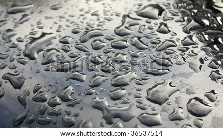 a group of raindrops on a black metal background