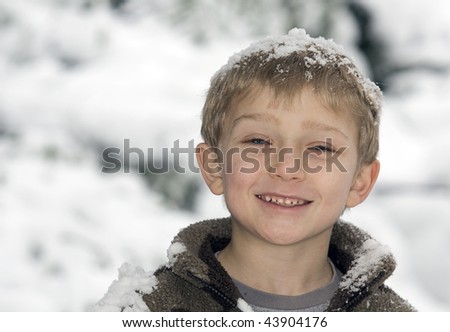a young blonde boy has fun in the snow