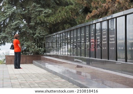 PYATIGORSK, RUSSIA - AUGUST 11, 2014: Memorial Eternal Flame, woman reading lists of the dead heroes of WWII