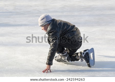 PYATIGORSK, RUSSIA - JANUARY 4, 2015: Open-air ice rink. Boy tries to get up after a fall on skates.