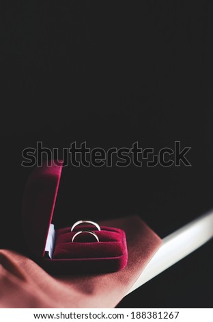 wedding rings in a gift box on a red cover