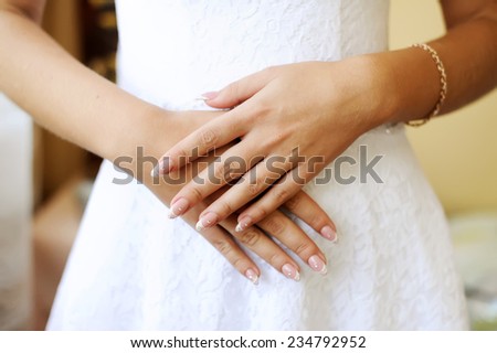 the bride\'s hands are crossed to a bracelet on a stomach