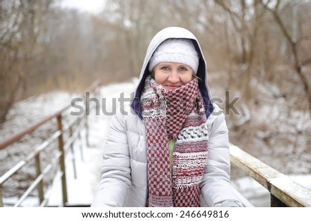 the woman goes on the bridge and holds the skates in hand