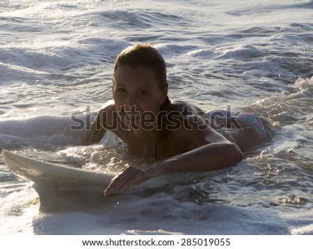 Surfer girl, Surfing surfer girl paddle for surf on surfboard. Female bikini woman living healthy active water sports lifestyle. Caucasian model
