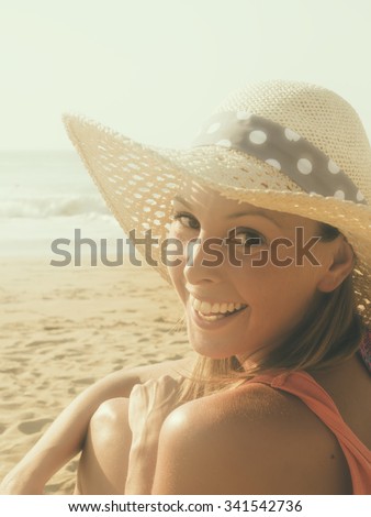 happy girl smiling profile photo in the beach  wearing a  hat with the sea and horizon in the background, portrait