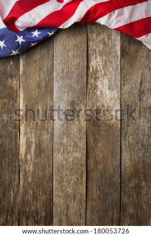 An American Flag Lying on an aged, weathered rustic wooden Background.