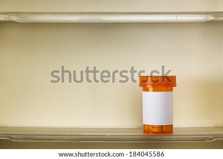 A single bottle of medicine on the shelf of a 1960\'s medicine cabinet.