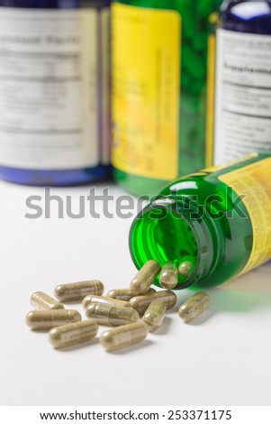 Health supplement capsules spilled from a bottle onto a table. Shallow depth of field.