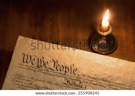 We the People are the opening words of the preamble to the Constitution of the United States illuminated by candle light.