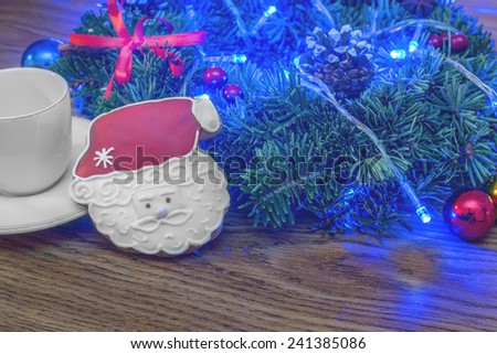 Christmas wreath on a wooden background red ribbon cookies Santa Claus coffee cup lights
