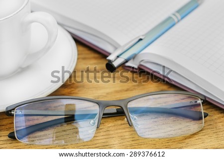 glasses pen on the table and pads