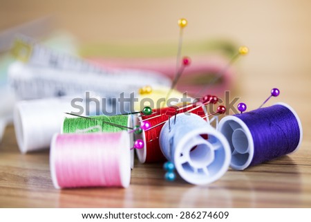 Sewing kit. Colored thread, pins, buttons, ribbons, safety pin.