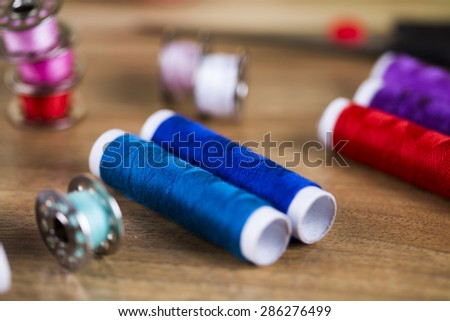 Sewing kit. Colored thread, pins, buttons, ribbons, safety pin.