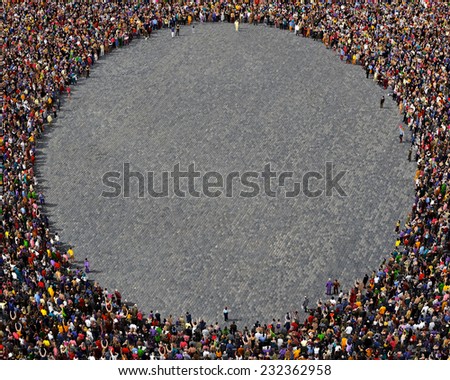 Large group of people seen from above, gathered in the shape of a circle, standing on street pavement background