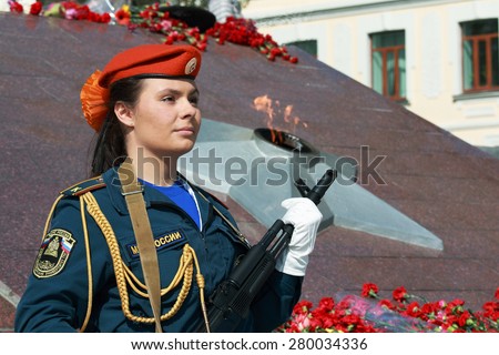 beautiful girl cadet the Russian Emergencies Ministry with arms in the honor guard at the Eternal Flame at the memorial in Vladivostok victory
