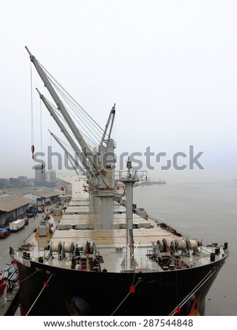 the ship with covered bilges is unloaded at the port in the rain