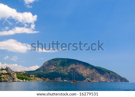 seaside landscape with blue sea and sky, cruise boat and rock
