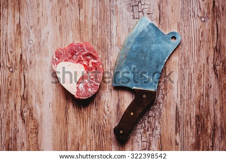 raw meat on a wooden background with sacking and an ax for chopping meat