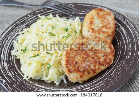Meat cutlets with noodles on brown plate and fork
