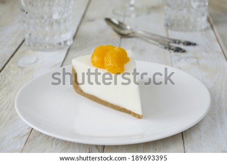 Low fat cheesecake with slices of mandarin on white background