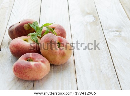 Saturn peaches or UFO, donut, flat peaches on white wood boards horizontal