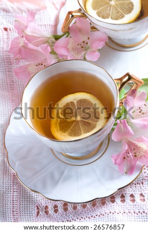 flavored tea in a white porcelain bowl and a pink flower freesia