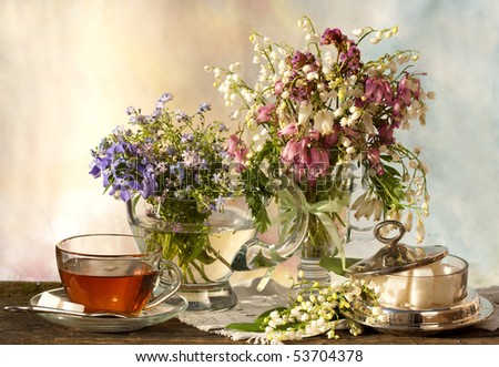 with lilies and a cup of tea and spring white and pink flowers Dicentra