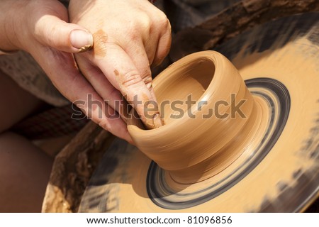 Close-up of potter turning a pot on a potter\'s wheel