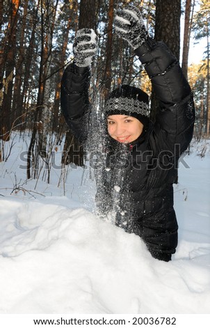 Young woman playing with snow on a cold day