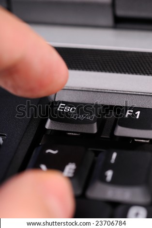 Finger hitting the Escape key